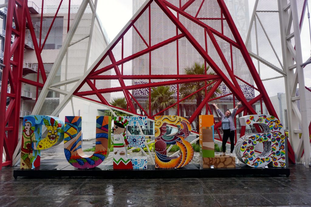 Zoe stood on the Puebla sign, each letter has a different design to represent the city