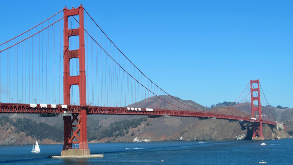 The golden gate bridge stands starkly against the dark blue of the San Francisco Bay and the light blue sky - no clouds on this day!