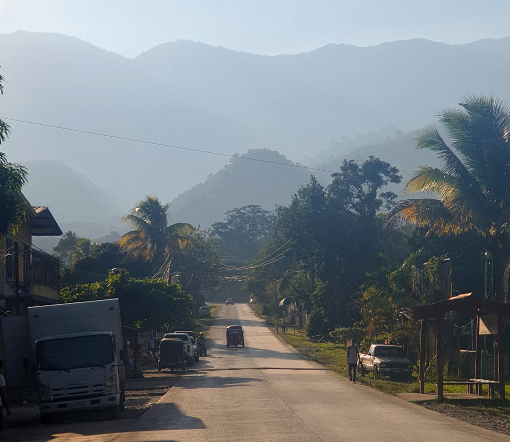 The main road through the town of Los Naranjos. The hills are in the background slightly obscured by the hazy light